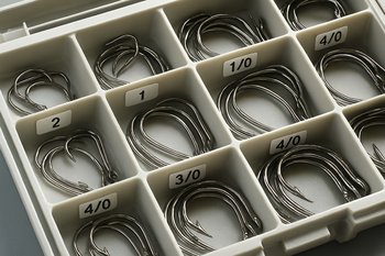 Поднос с разложенными рыболовными крючками, под каждым подпись маркером