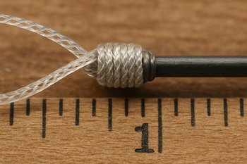 Крупный план узлов на рыболовной леске, зафиксированных на линейке