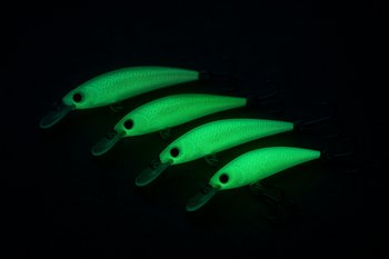 Светящиеся в темноте приманки разложены на столе рядом с удилищем