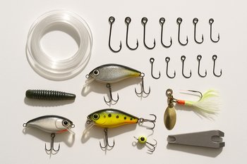 Карманный набор снастей разложен на столе рядом с небольшим блокнотом