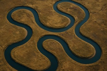 Река сверху, хорошо видны полосы разных струй и изгибы русла